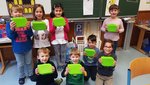 Mehrere Kinder halten ihre grünen Brotdosen in der Hand